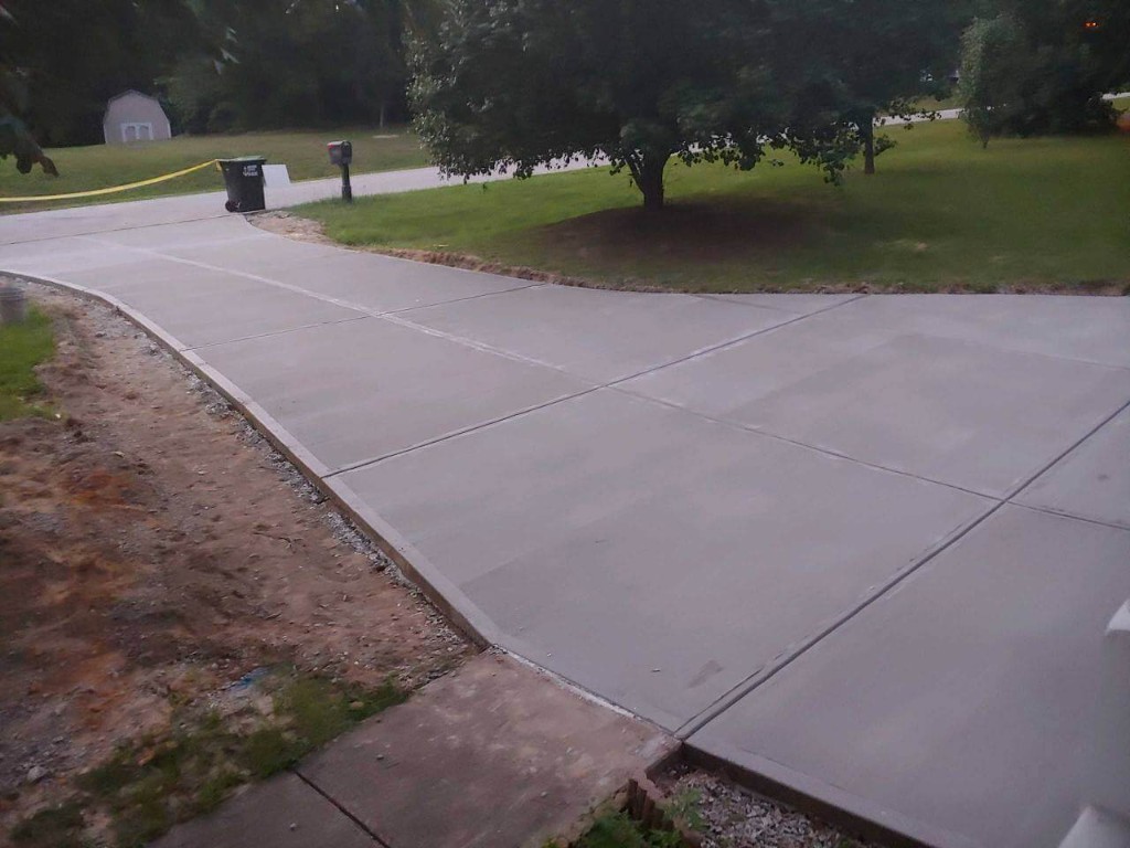 Freshly finished concrete driveway with clean expansion joints at a residential property