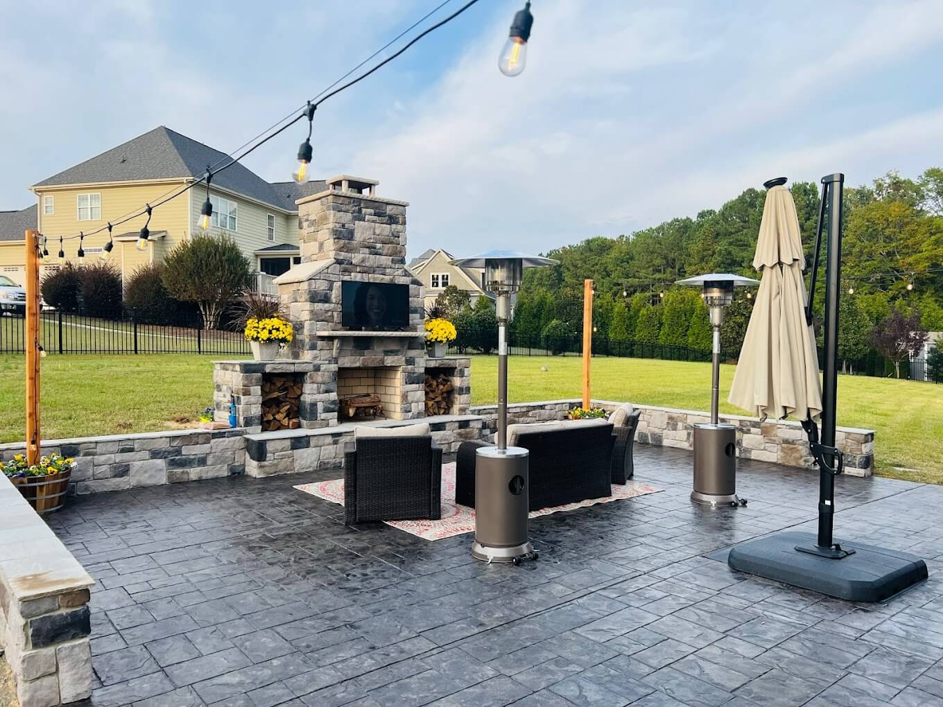 Outdoor fireplace with stamped concrete patio and furniture